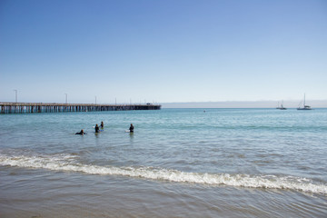 Fototapeta na wymiar surfers in the ocean at Pismo Beach, California