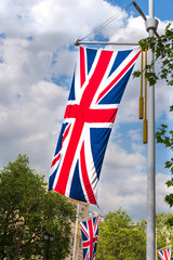 Union Jack flag of the United Kingdom of Great Britain hanging from pole with tassels on the Mall in London