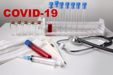 medical laboratory test tube with blood inside, stethoscope, syringe, protective masks, concept of...