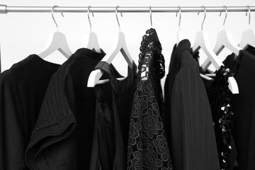 set of women's clothing in black in different colors on hangers, a concept for fashion, mourning...
