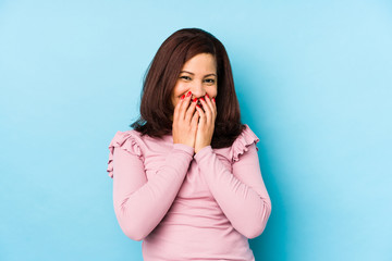 Middle age latin woman isolated laughing about something, covering mouth with hands.