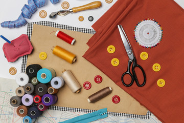 Set of different sewing items - top view of scissors, threads,buttons,  sewing needles, fabric and patterns