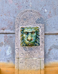 A lion's head, old European city fountain detail.