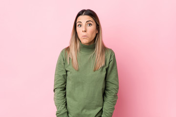 Young caucasian woman isolated shrugs shoulders and open eyes confused.