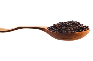 Brown lentils in the wooden spoon isolated on a white background.