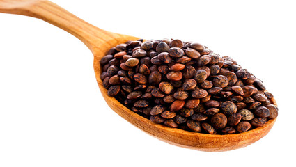 Brown lentils in the wooden spoon isolated on a white background. Top view.