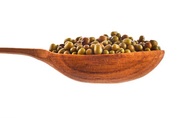 Green lentils in the wooden spoon isolated on a white background.