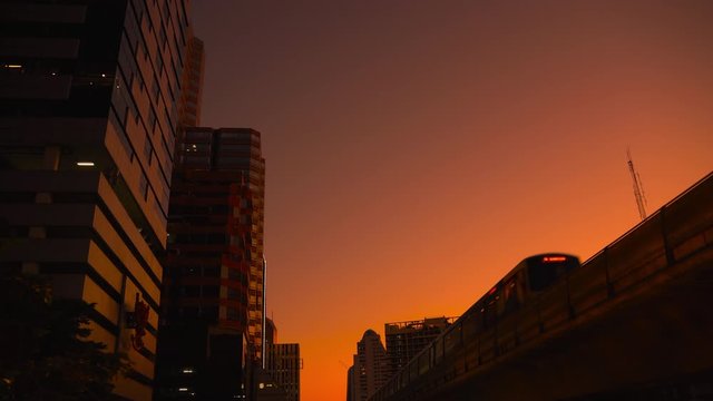Electric train in monorail system, raised above the ground in Bangkok at dusk