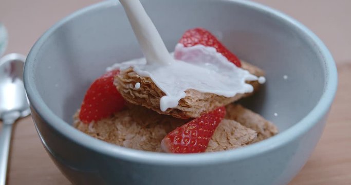 Dynamic milk pour on bowl of breakfast cereal and strawberries (Phantom 4K 1000fps)