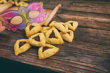 Jewish cookies with jam on oven table with mask.