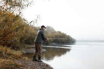 A man is fishing on the river. Fisherman on a morning fishing trip