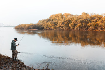 A man is fishing on the river. Fisherman on a morning fishing trip