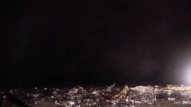 Glass olive oil bottle breaking in slow-motion.