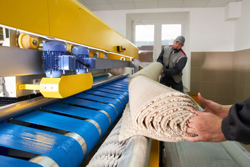 Laundry workers in the process of working on automatic machine for carpet washing in dry cleaning