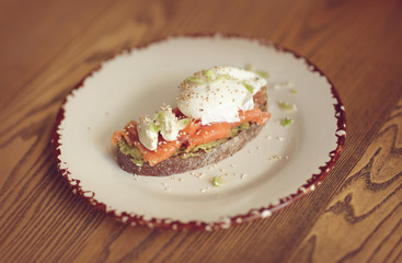 open sandwich with light-salted salmon and poached egg and avocado