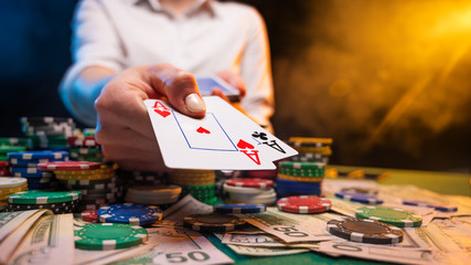 Playing in a casino, online casino. A player opens cards with two aces. Money, poker table, chips....