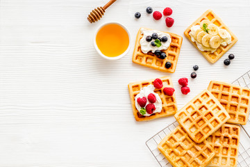 Beautiful yummy snacks. Waffles with cream and friuits on white background top-down frame copy space