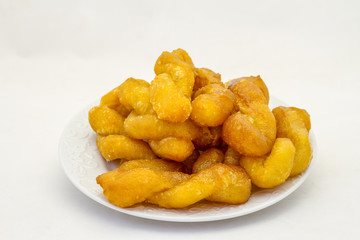 Koeksisters are traditional Afrikaner confectionery made of fried dough infused in syrup or honey isolated on a white background in horizontal format with copy space