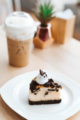 Chocolate cookies and cream cheese cake, biscuits eaten together with cold cappuccino on the back