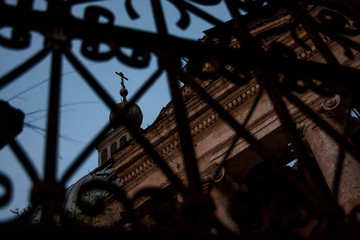 iron gate against the background of the dome of an abandoned church
