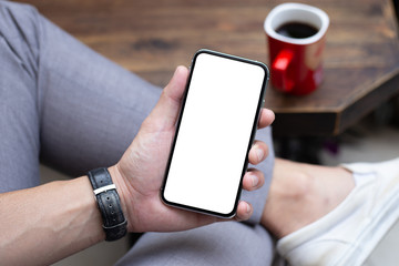 Mockup image blank white screen cell phone.man hand holding texting using mobile on desk at coffee shop.background empty space for advertise text.people contact marketing business,technology