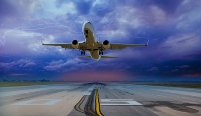 Commerical airplane taking off from airport runways for traveling with stormy weather and lightning