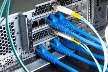 Lan and fiber optic cables are plugged into the back panal of the server.