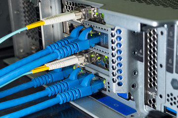 Lan and fiber optic cables are plugged into the back panal of the server.