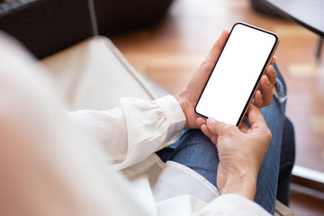 Mockup image blank white screen cell phone.woman hand holding texting using mobile on desk at coffee shop.background empty space for advertise text.people contact marketing business,technology