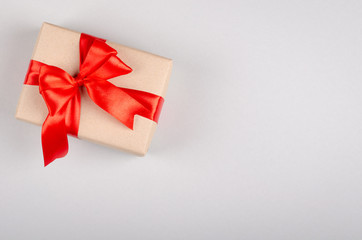 Gift box on gray background composition, present with ribbon and bow.