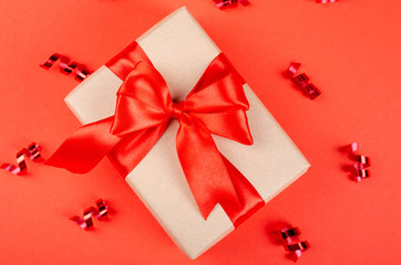 Gift box on red background composition, present with ribbon and bow.