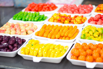 Fruit-shape desserts made of mung-bean flour with natural coloring on the wooden spoon with wood background. It is one of a famous Thai dessert