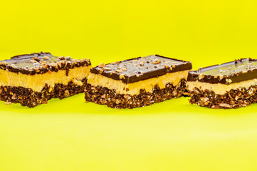 Nutty brownie bars on a yellow background