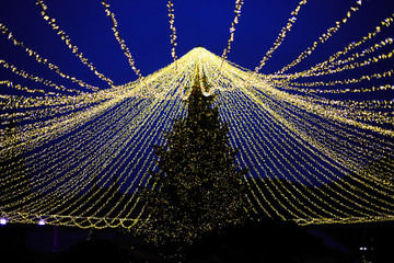 наряженная елка  с гирляндами паутиной и со сверкающей звездой 