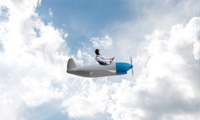 Man in aviator hat driving propeller plane