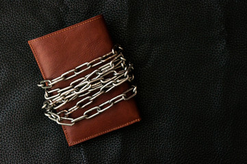 Business safety and finance protection concept - metal chain link on leather wallet