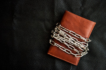 Business safety and finance protection concept - metal chain link on leather wallet