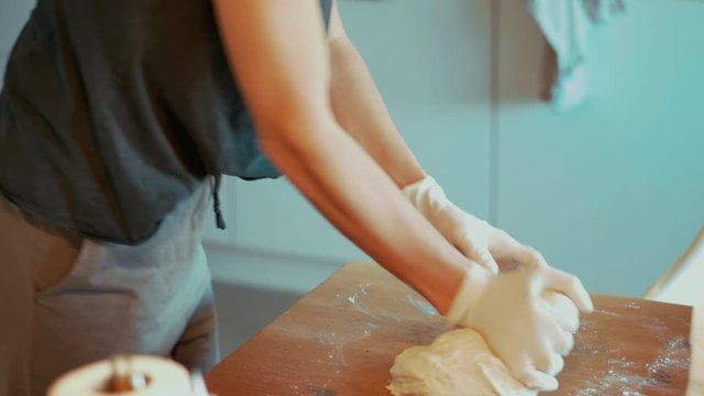 Mutter rollt Pizzateig in der K&uuml;che