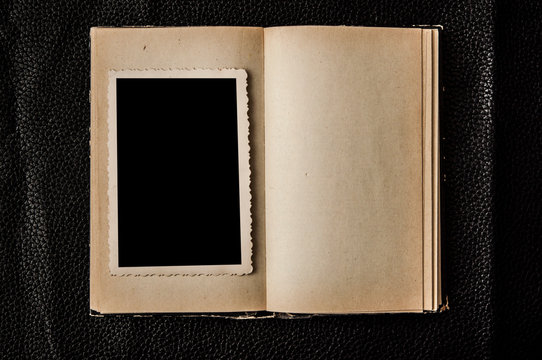 Photo blank. Open old book on black leather background