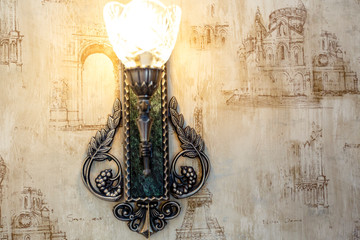 Vintage electric light on the wall with beige Wallpaper and pattern