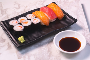 CloseUp Salmon sushi on a black plate. With wasabi and shoyu sauce. Focus salmon sushi.