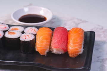 CloseUp Salmon sushi on a black plate. With wasabi and shoyu sauce. Focus salmon sushi.