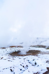 An erupting soaring geyser in the Valley of Geysers. Magnificent Iceland in the winter.