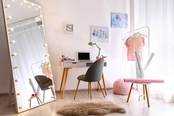 Large mirror with light bulbs in stylish room interior