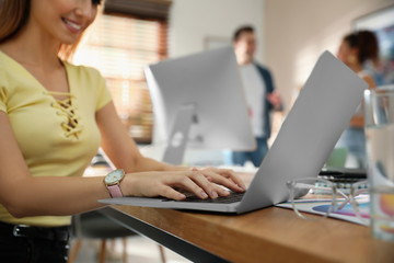 Female designer working with laptop at table, closeup