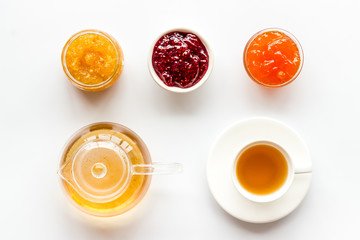 Fruit jam near tea on white kitchen desk