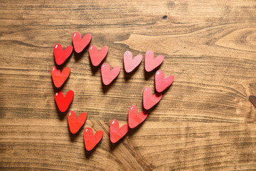 Red hearts on a wooden surface background with text space. The concept of love, feelings and care