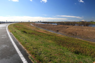 土手から見る早春の雨上がりの江戸川河川敷風景