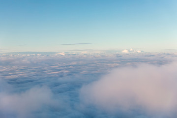 Aerial view of fluffy clouds through an airplane window