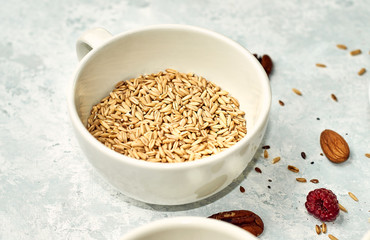 Raw oatmeal in a ceramic cup on the table. Healthy food
